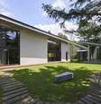 Casa térrea com anexo, em meio a um jardim arborizado em dia de sol  Foto: Symbiotic House/Masaya Yoshimura/A House in Japan, Ed. Gestalten / BBC News Brasil