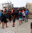 Policiais e militares espanhóis escoltam migrantes de volta ao Marrocos, em Ceuta, em 1º de agosto de 2026.  Foto: REUTERS - Jon Nazca / RFI