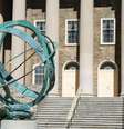Um relógio de sol de metal no campus da Universidade Estadual da Pensilvânia, com o prédio Old Main ao fundo, um marco local em State College, Pensilvânia, EUA.  Foto: Getty Images / BBC News Brasil