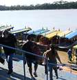 Em 11 de agosto de 2026, pessoas chegam de barco pelo rio Mamoré em Guayaramerín, na fronteira entre a Bolívia e o Brasil, no departamento de El Beni, na Bolívia.  Foto: © AIZAR RALDES / AFP / RFI
