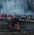 Apoiadores de Ratko Mladic exibem sua foto e acendem sinalizadores para homenagear o ex-general sérvio na ponte Varadinski, em Novi Sad, na Sérvia, em 27 de agosto de 2026.  Foto: RFI