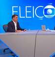 O momento em que Renata Vasconcellos passa a folha com a pergunta que Tralli não tinha localizado  Foto: Reprodução