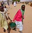 Jovens refugiadas sudanesas transportam água perto de uma seção eleitoral no campo de refugiados de Zamzam, nos arredores de El Fasher, em Darfur, no Sudão. (Imagem ilustrativa)  Foto: RFI