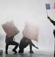Manifestante mascarado segura bandeira francesa durante protestos de estudantes e confrontos com forças de ordem, em Paris, em 13 de outubro de 2026.  Foto: REUTERS - Sarah Meyssonnier / RFI