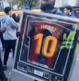 Foto: Reprodução de vídeo - Legenda: Manifestante exibe relíquia de Messi roubada de uma loja durante protestos em Paris / Jogada10