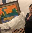 Policiais seguram o quadro O Sol Poente após recuperá-lo de furto em 2022, antes de a obra ser oferecida a Vorcaro Foto: Reuters / BBC News Brasil