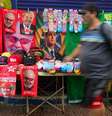 Ambulante com toalhas de Lula e Flávio Bolsonaro a venda na rua Siqueira Campos, em Copacabana, zona sul do Rio de Janeiro.  Foto: Pedro Kirilos/Estadão / Estadão