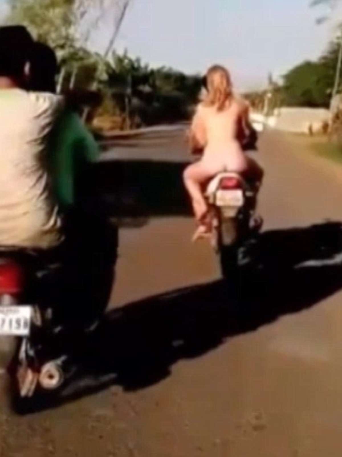 Mochileiros europeus viajam pelados em moto em Camboja