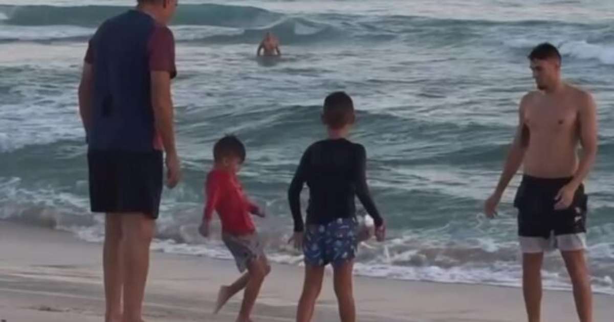 Tite demonstra habilidade em altinha com netos na praia da Barra.