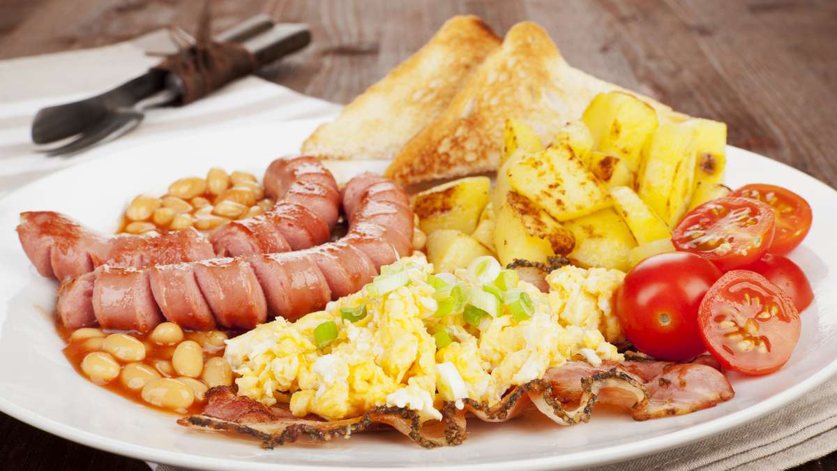 Café da manhã inglês com ovos fritos, bacon, queijo, tomate no