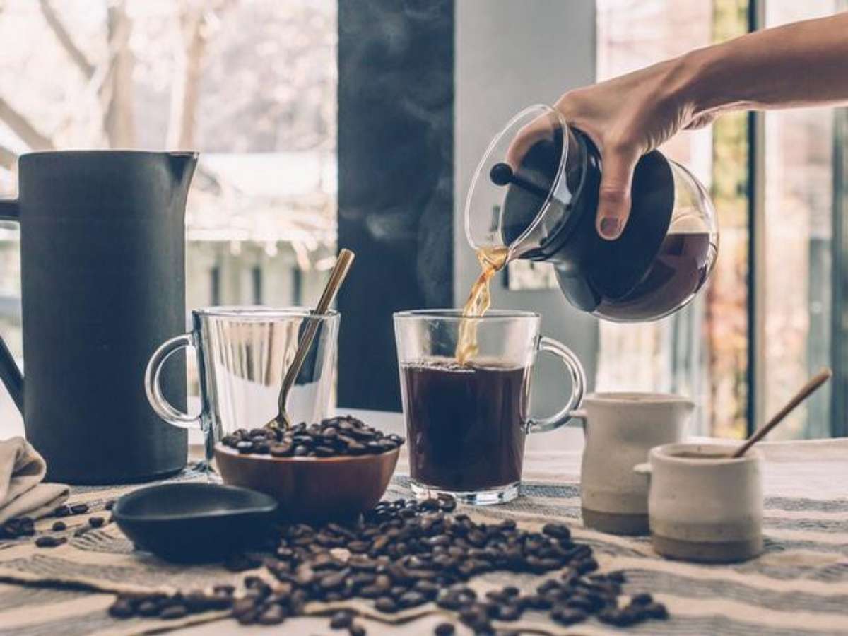 Mulher jovem e bonita com uma xícara de café de plástico na mão