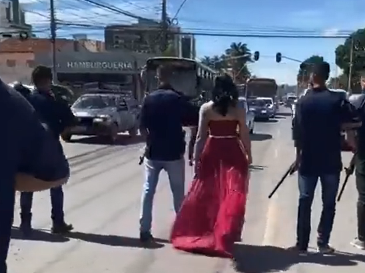 Dama de vermelho faz ensaio de casamento e para trânsito com homens armados