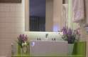 O vaso de lavandas e os puxadores em lilás e verde complementam a decoração do banheiro
