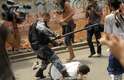 Homem caído na frente de um policial militar na região do Maracanã