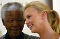 Mandela abraça a atriz sul-africana Charlize Theron após ela se tornar a primeira mulher africana a ganhar o Oscar, em Johanesburgo, no dia 11 de março de 2004