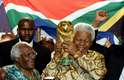 Mandela exibe o troféu da Copa do Mundo ao lado do arcebispo sul-africano Desmond Tutu após a Fifa anunciar a África do Sul como sede do campeonato mundial de futebol de 2010, em Zurique, na Suíça, no dia 15 de maio de 2004