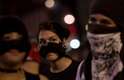 Jovem usa lenço no rosto para se proteger de bombas de efeito moral