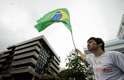 22 de junho - Com bandeira do Brasil, manifestante faz coro a protesto na frente da casa de Cabral