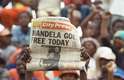 Manifestante celebra libertação de Mandela com jornal que traz a notícia em sua capa, em Soweto, em 11 de fevereiro de 1990