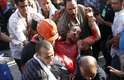 Seguidores de Mursi carregam companheiro ferido no tiroteio