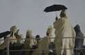 23 de julho - Religioso se protege da chuva durante a missa de abertura da Jornada Mundial da Juventude, em Copacabana