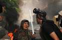 14 de agosto - Mulher com um pedaço de pau nas mãoes conversa com policial em acampamento pró-Mursi