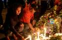 Sul-africanos se reuniram na noite de domingo em frente à casa de Mandela em Johanesburgo para prestar homenagem ao falecido líder