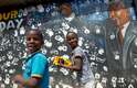 Crianças brincam e sorriem em frente a mural a 'Madiba'