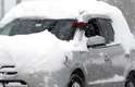 2 de janeiro - Motorista para o carro para tentar remover a neve do para-brisa, em Chicago