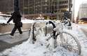 7 de janeiro - Homem caminha ao lado de bicicleta congelada com os termômetros já abaixo dos zero graus em Chicago