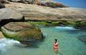 19 de março - Banhista aproveita mar verde e dia de sol para se refrescar na praia do Arpoador, no Rio de Janeiro