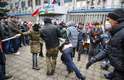 12 de abril - Um homem armado é detido pelos manifestantes pró-russos, durante um comício em Luhansk.