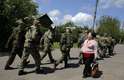11 de maio - Mulher cumprimenta um grupo de pró-russos armados, enquanto eles marchavam em direção a uma mesa de voto durante um referendo em Slaviansk