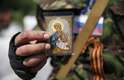 29 de maio - Membro de um grupo separatista pró-russo mostra uma imagem de um ícone religioso, em seu uniforme