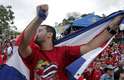 Torcedor beija a bandeira da Costa Rica durante comemorações na cidade de San Jose