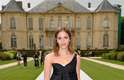 A atriz Emma Watson usou um vestido mullet de um ombro só, em camadas, para ver o desfile da Dior