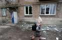 Criança passa por um prédio, que, segundo os moradores, foi danificado por bombardeios recentes na cidade controlada pelos separatistas de Yasynuvata (Yasinovataya) na região de Donetsk, Ucrânia
