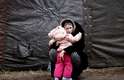 Dia 28/2 - Mulher abraça a filha em campo de refugiados na Polônia