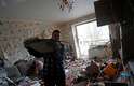 Dia 2/3 - Homem retira destroços de apartamento atingido durante guerra entre Rússia e Ucrânia