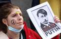 Dia 2/3 - Manifestante ergue cartaz que compara Putin a Adolf Hitler em ato na Bélgica
