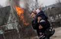 Dia 7/3 - Homem e criança fogem de bombardeios em Irpin, na Ucrânia