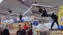 Policial sobe em gôndola para tirar homem pendurado no teto de supermercado