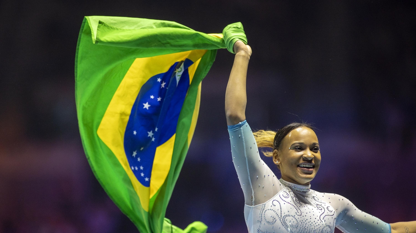 Rebecca Andrade comemora com a bandeira brasileira após conquistar a medalha de ouro durante a final individual individual feminina no Campeonato Mundial de Ginástica-Liverpool 2022.   Foto: Tim Clayton/Corbis via Getty Images