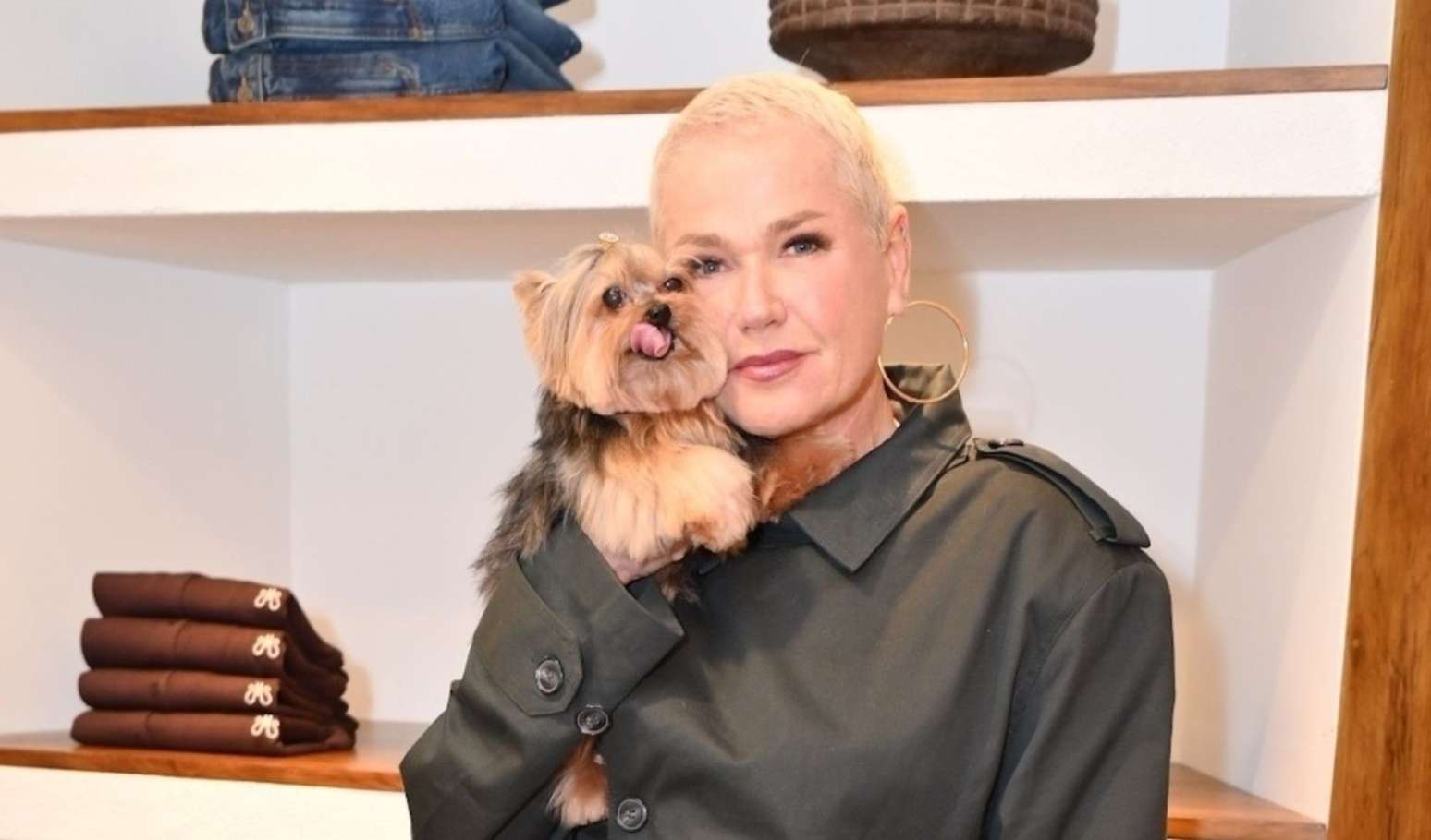 Xuxa segura a cadela Doralice ao chegar ao aeroporto de Curitiba