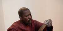Homem observa manuscrito parcialmente queimado em Timbuktu após expulsão dos terroristas islâmicos  Foto: AFP