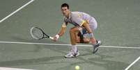 Djokovic se agacha para fazer bate-pronto na vitória sobre Seppi  Foto: Reuters