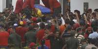 Caixão com o corpo de Chávez é retirado do carro na Academia Militar, após um cortejo de seis horas que reuniu milhares de pessoas pelas ruas de Caracas  Foto: AP