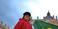 <p>Enrolada em uma bandeira do Brasil, Kathya Zanardi disse que esse momento 'é o máximo para a fé católica'</p>  Foto: Rafael Belincanta / Especial para Terra