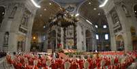 <p>De vermelho e sentados, cardeais acompanham a missa <em>Pro Eligendo Pontifice</em>&nbsp;na manh&atilde; desta ter&ccedil;a-feira</p>  Foto: AFP