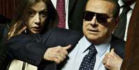 Sob protestos, Berlusconi chegou ao Senado usando óculos escuros  Foto: AP
